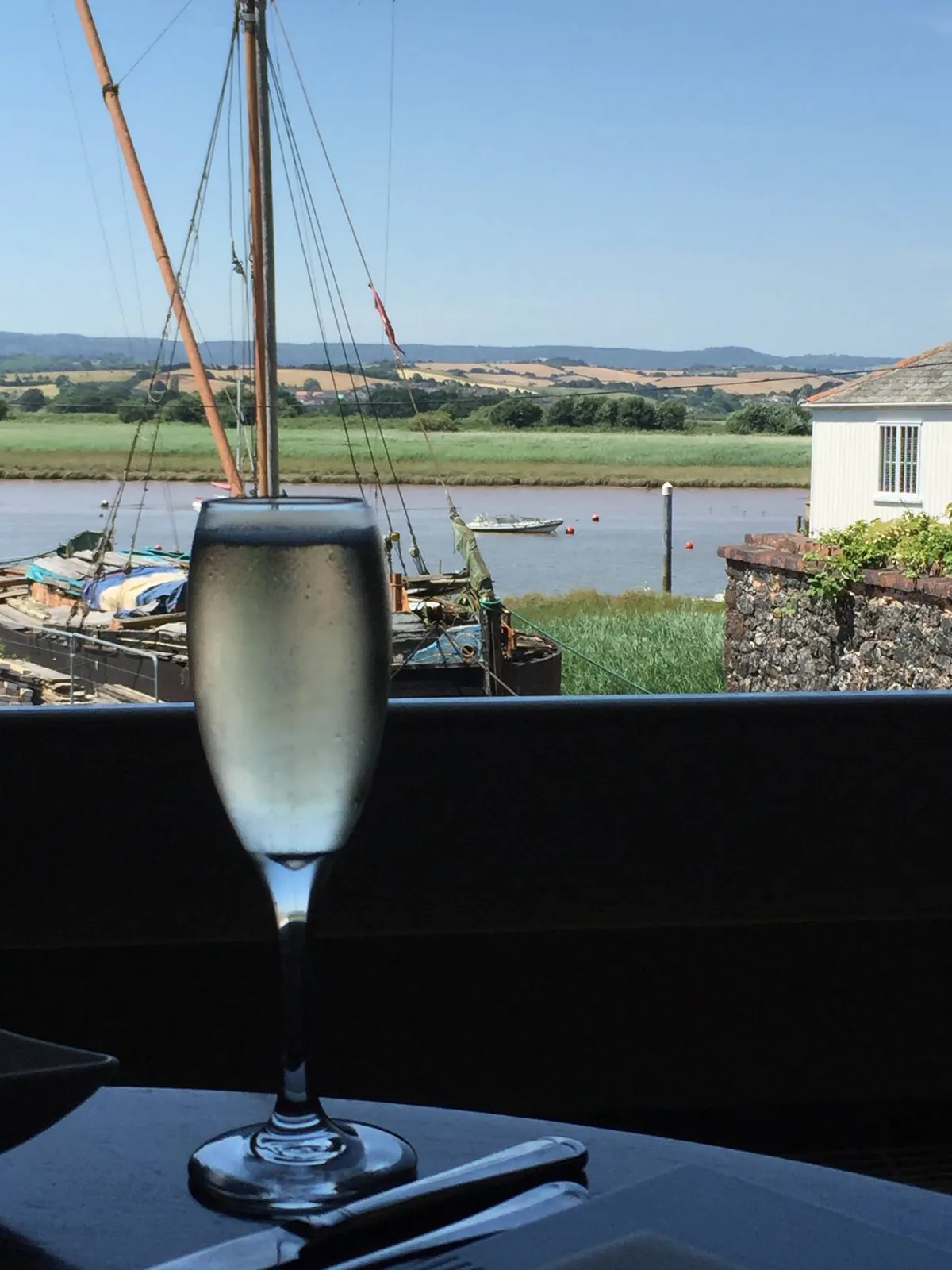 A glass of white wine looking out over the Exe estuary from the upstairs dining room