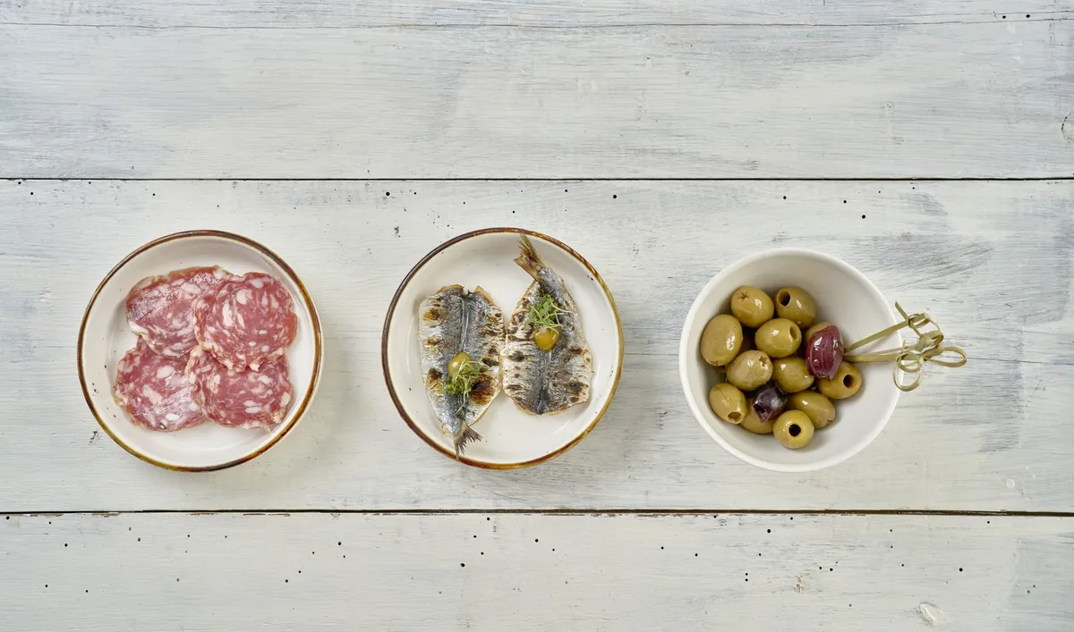 Three small plates — cured meats, grilled sardines and olives