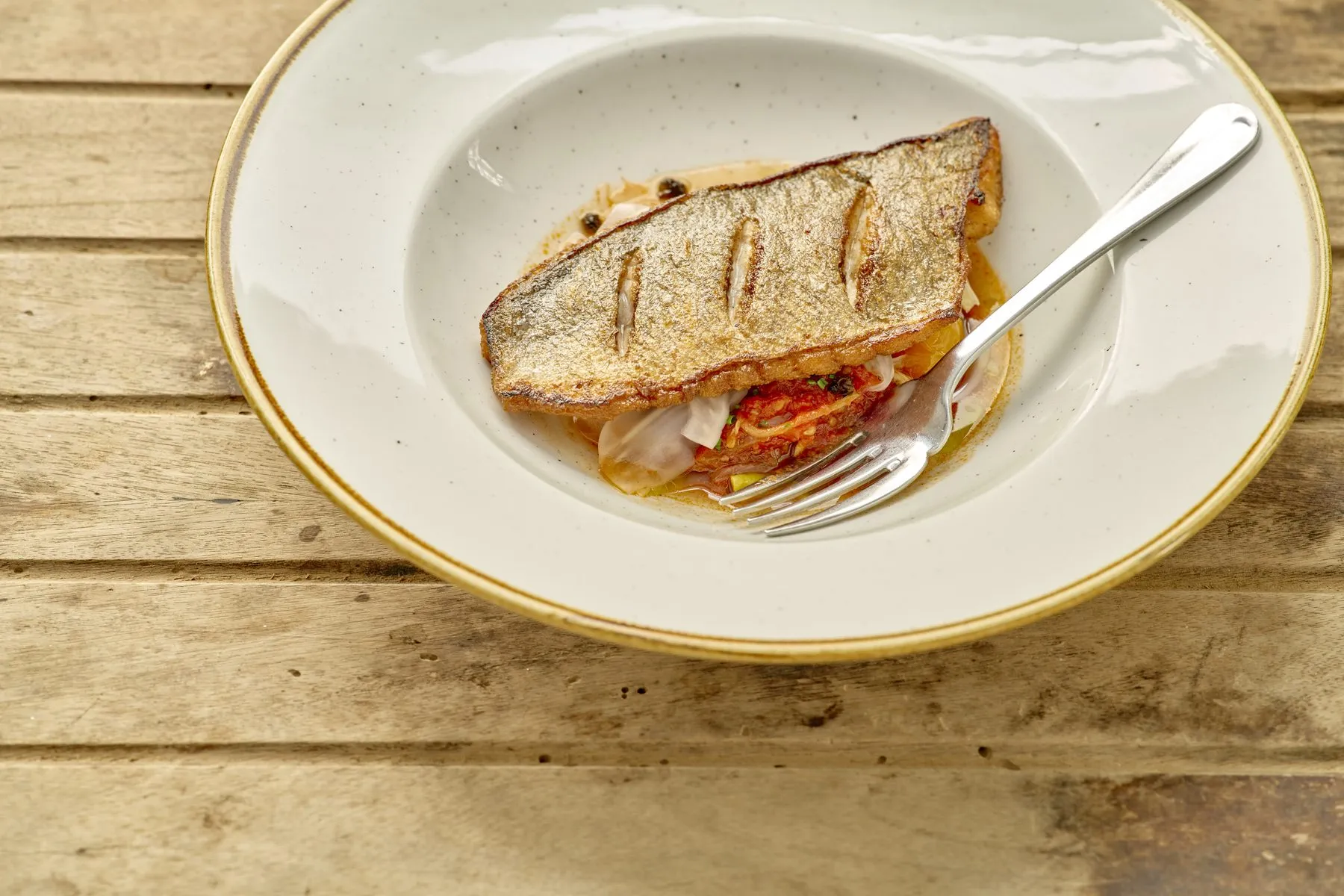 Pan-fried sea bream on a wide white plate
