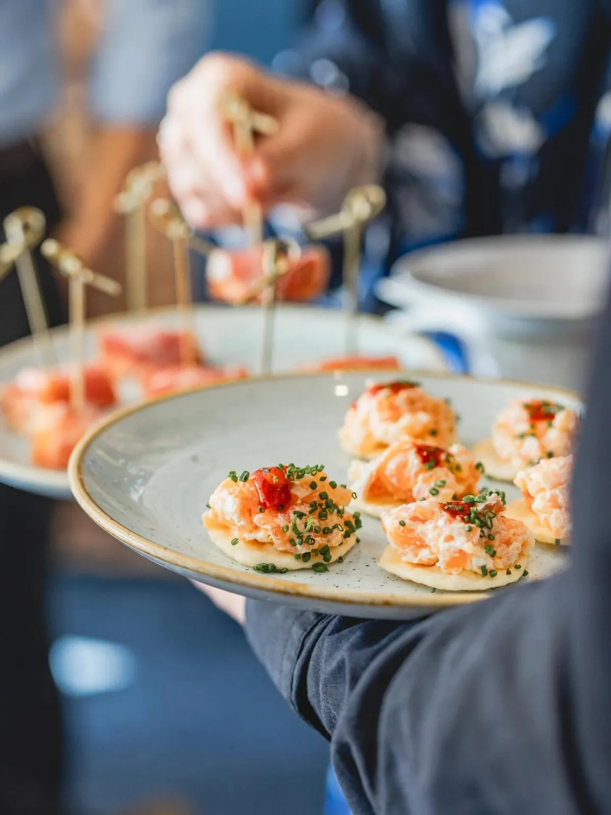 Salmon canapés on blinis with chives, served on a speckled Galley plate
